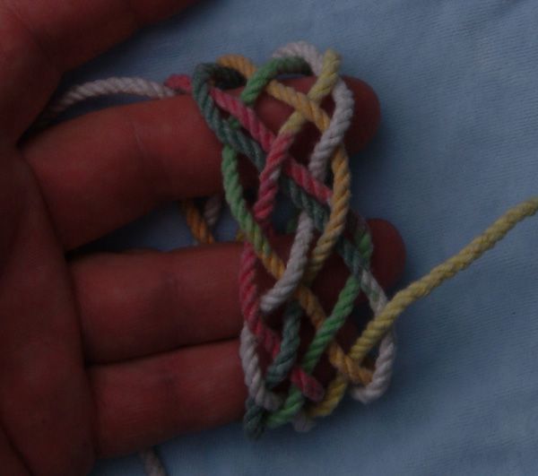 Tying a seven-lead eleven-bight knot in hand.